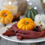 Photo of pumpkins and candle on a wooden table