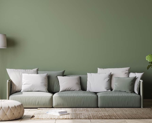 Image of Scandinavian home decor with green couch, rattan pot and floor lamp