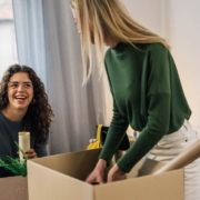 Caucasian female students unpacking in students room