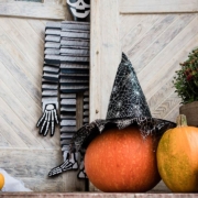 Halloween decorated front door with various size and shape pumpkins and skeletons
