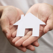 Hands holding paper house