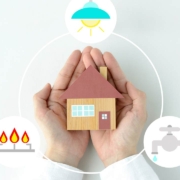 Human's hands and house object with gas, electricity and water icons