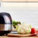 Modern pot with multicooker and products on kitchen table