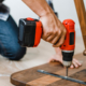 Man using hand drill to assemble a wooden table