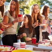 Girls stand talking at a block party food table, close up