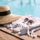 Sunglasses and straw hat on the wooden floor at the pool