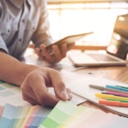 Man with laptop and paint swatches to select a new color