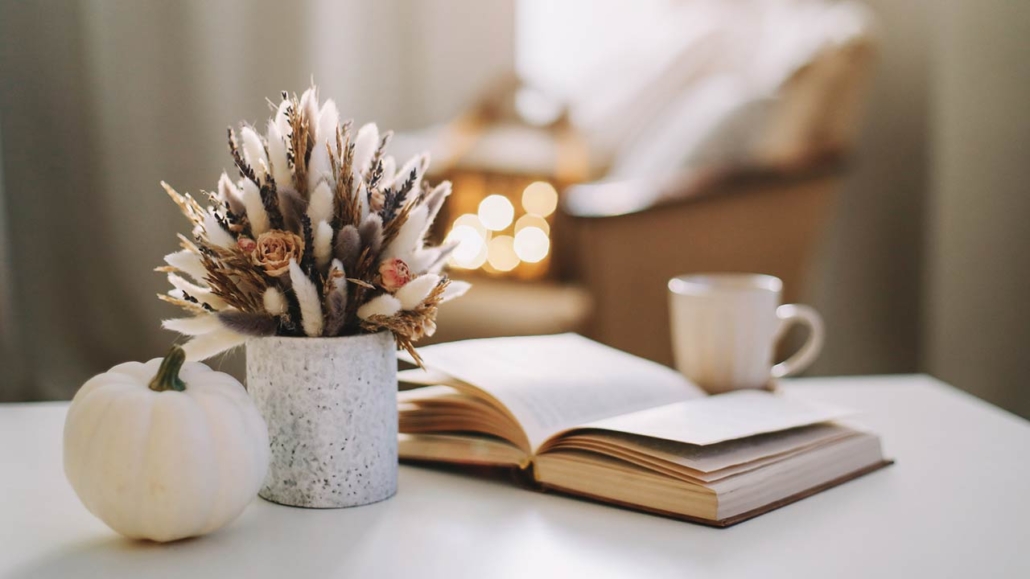Fall home decoration stock photo with dried flowers, book, and a teacup