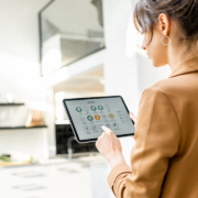 woman controlling smart home devices using a digital tablet with launched application in the white living room