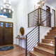Chic entrance foyer with high ceiling and wide staircase with lights and contemporary railing