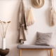 Cosy entryway with grey bench, coffee table, hanger and personal accessories stock photo